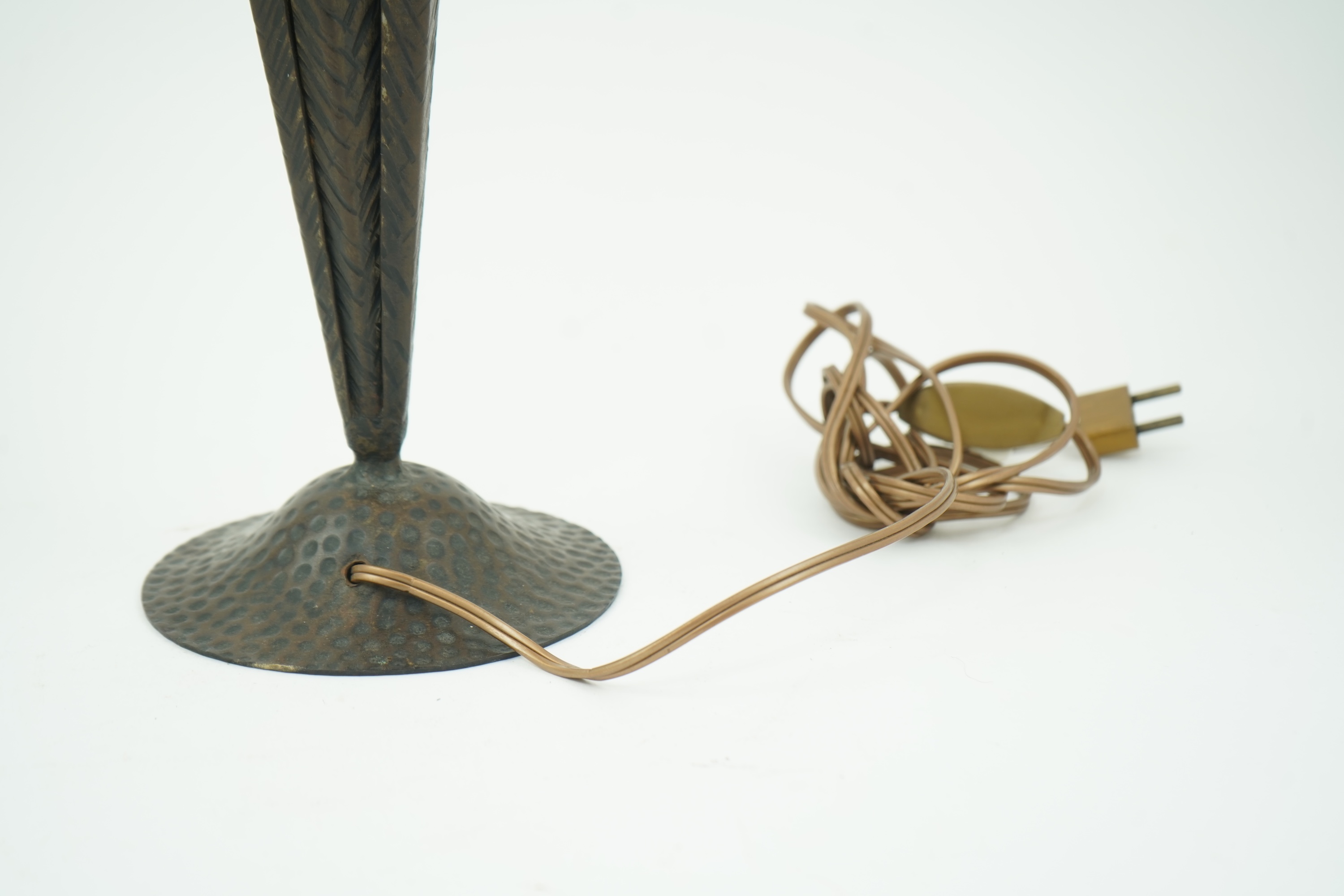 Manner of Muller Freres and Robj: A French Art Deco table lamp the mottled orange glass shade supported by naturalistic palm-leaf metal supports terminating in a circular hammered metal base, 40cm high